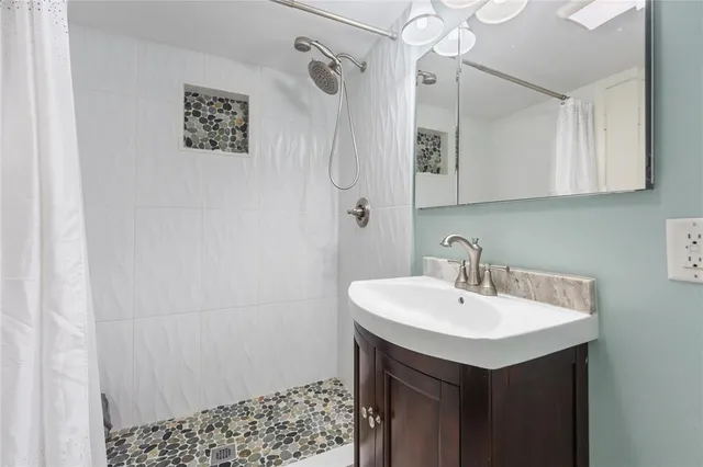 a bathroom with a sink a mirror and shower