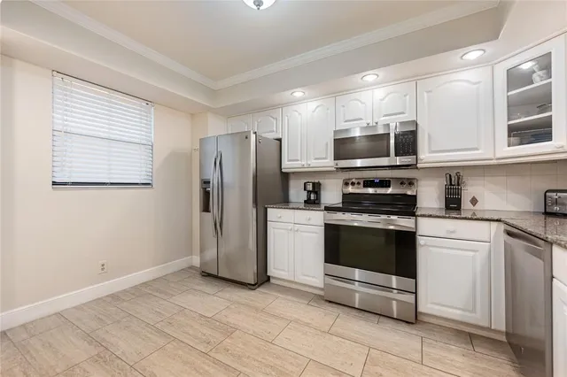 a kitchen with stainless steel appliances granite countertop a refrigerator and a stove top oven