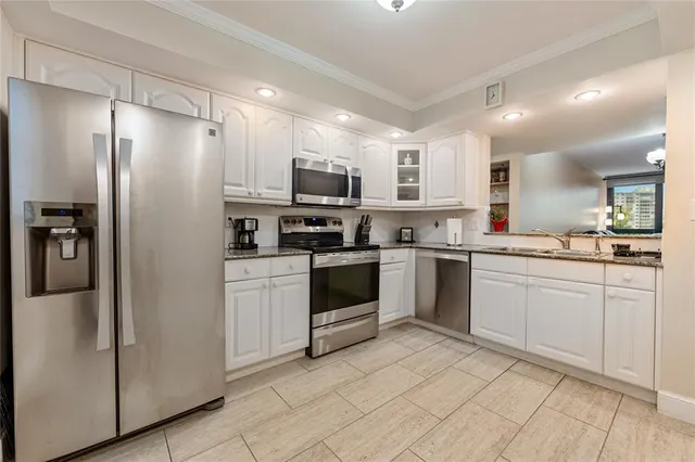a kitchen with white cabinets and stainless steel appliances