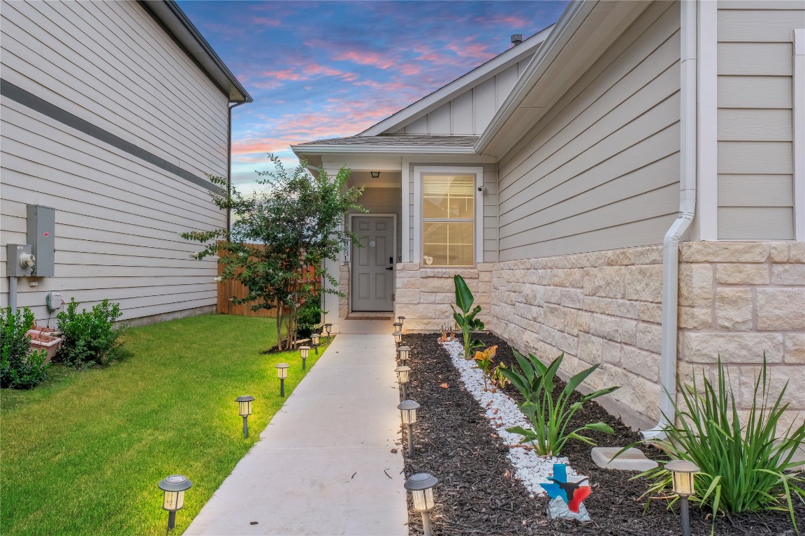 323 Tolo Drive Elgin, TX 78621 - Photo 2 of 32 Property entrance featuring a yard, stone siding, and board and batten siding