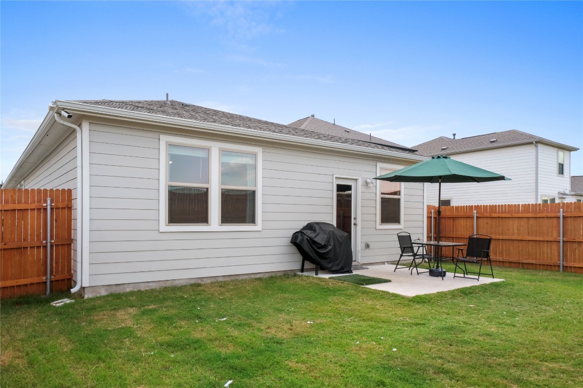 323 Tolo Drive Elgin, TX 78621 - Photo 25 of 32 Back of property featuring a fenced backyard, a patio area, and a shingled roof