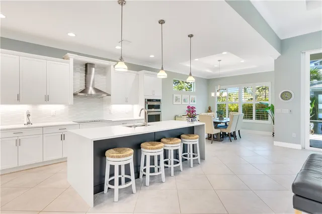 a kitchen with living room and chairs