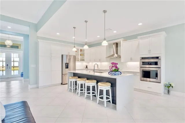 a kitchen with stainless steel appliances kitchen island granite countertop a table chairs sink and cabinets