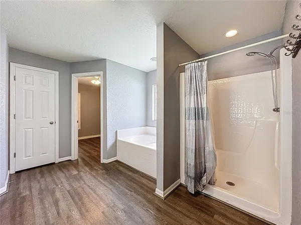 a view of room with hardwood floor and a ceiling fan
