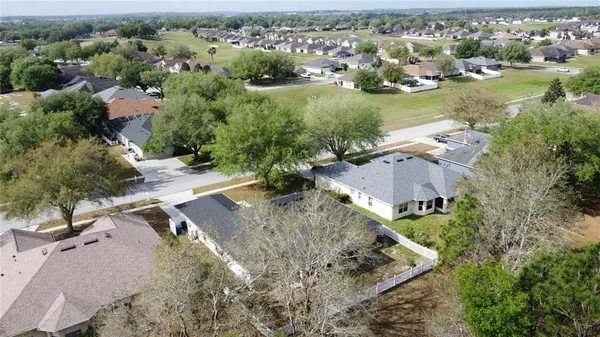 a view of a house with a yard and large tree