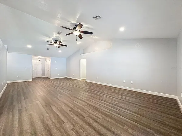 a view of an empty room with wooden floor