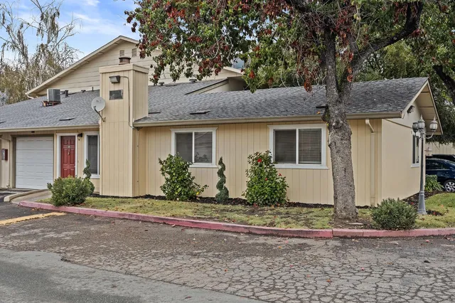 a front view of a house with a yard and potted plants