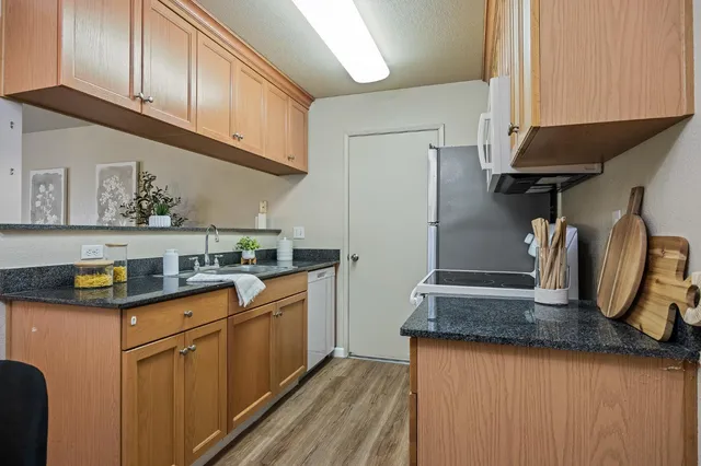 a kitchen with stainless steel appliances granite countertop a sink a stove and refrigerator