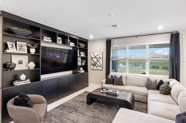 a kitchen with stainless steel appliances kitchen island granite countertop a table chairs stove and white cabinets