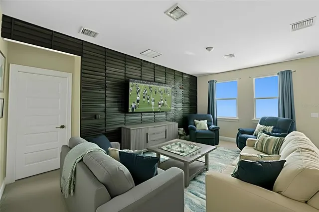 a living room with furniture a flat screen tv and a window