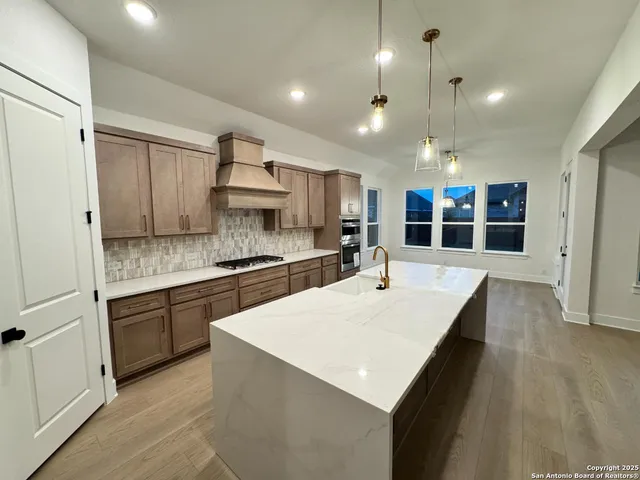 a kitchen with kitchen island a sink stove and refrigerator
