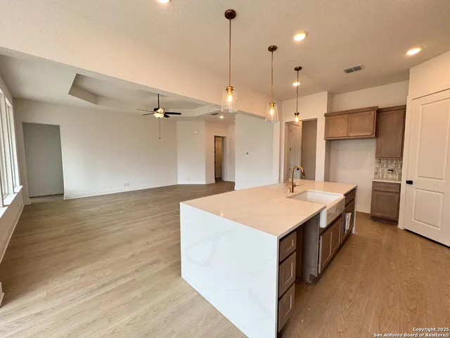 a large kitchen with kitchen island a sink stainless steel appliances and a chandelier
