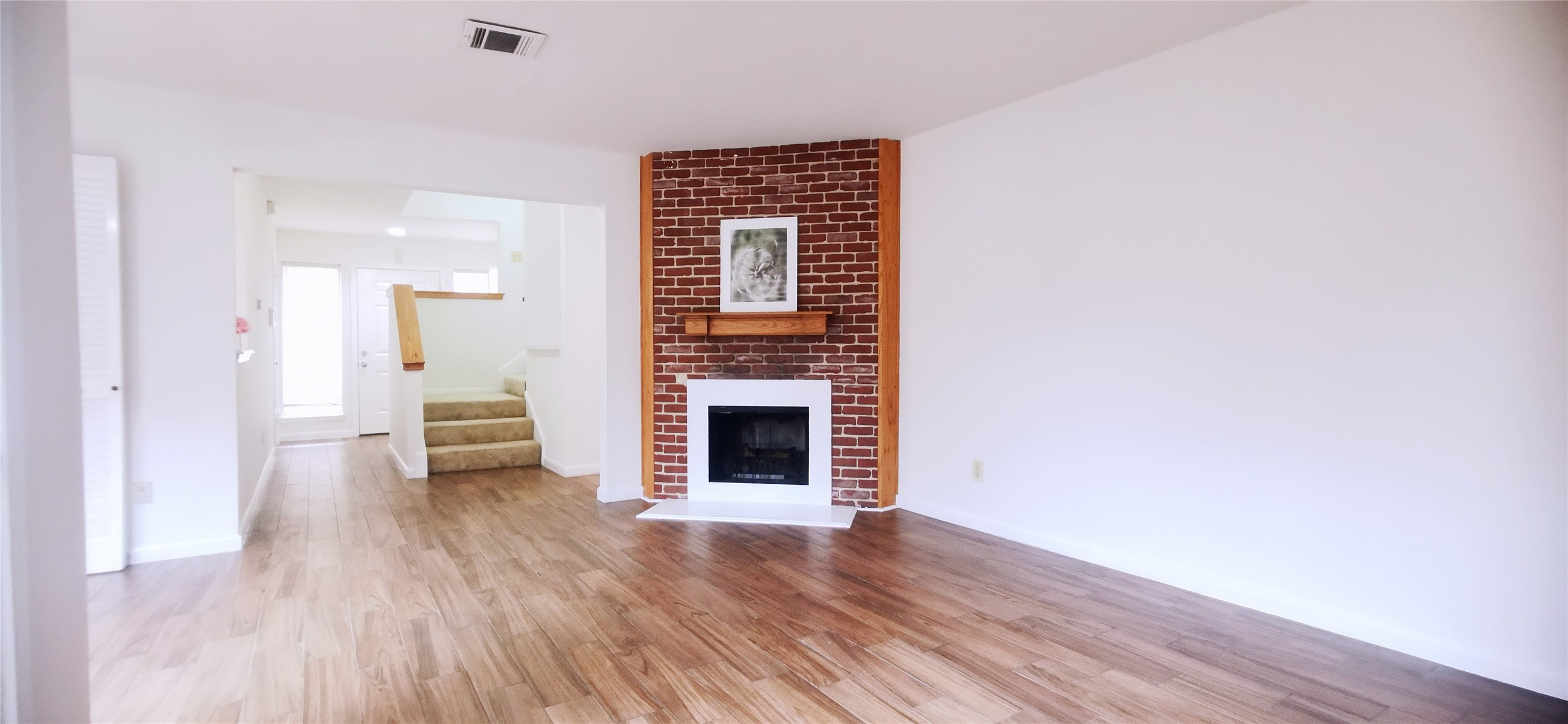 8313 Augustine Drive, Unit B Houston, TX 77036 - Photo 12 of 34 a view of an empty room with wooden floor and a fireplace