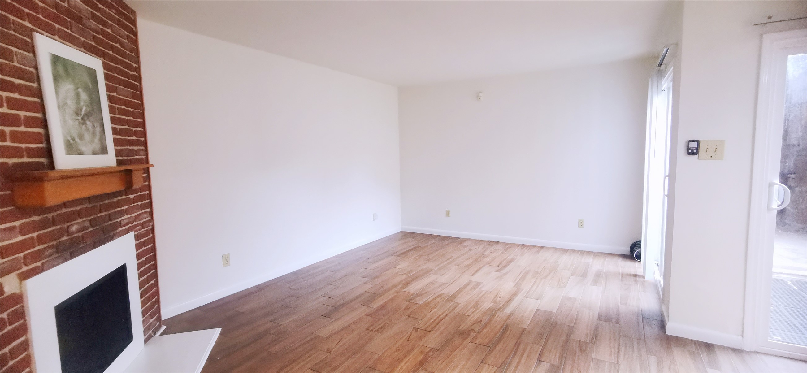 8313 Augustine Drive, Unit B Houston, TX 77036 - Photo 10 of 34 a view of empty room with wooden floor and fireplace