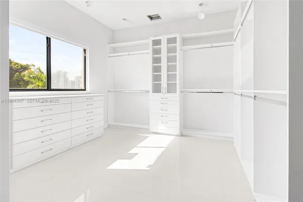 a view of walk in closet with empty racks