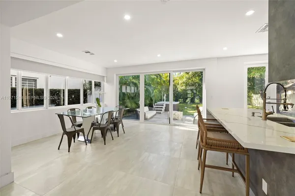 a dining room with furniture window garden view and a wooden floor
