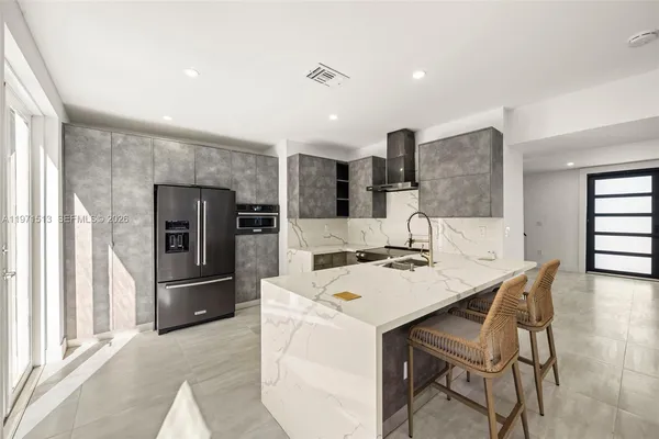 a kitchen with a refrigerator a stove a sink and a dining table