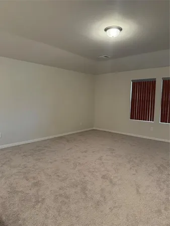 an empty room with a window and ceiling fan