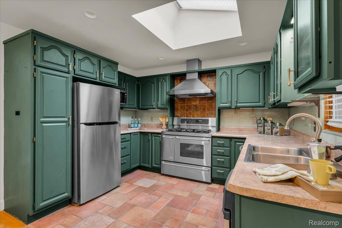 1156 Seneca Road Lake Orion, MI 48362 - Photo 7 of 50 Kitchen featuring green cabinetry, light countertops, stainless steel appliances, wall chimney exhaust hood, and tasteful backsplash