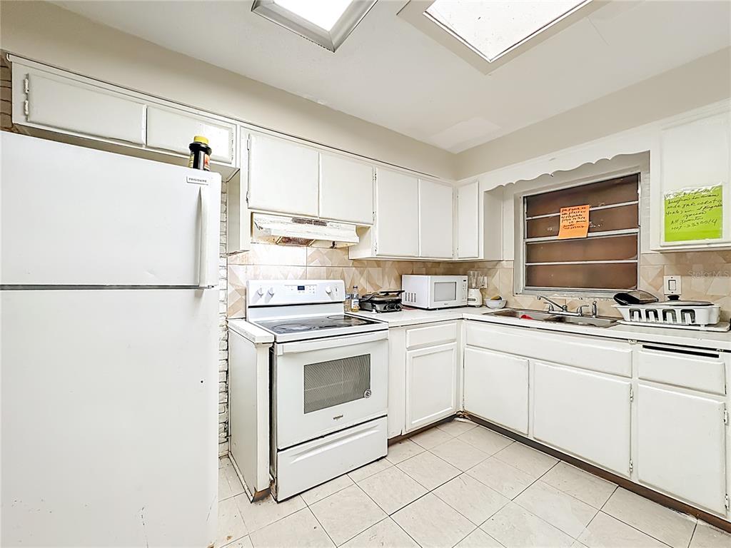 4200 Anderson Road Orlando, FL 32812 - Photo 11 of 63 a kitchen with stainless steel appliances granite countertop white refrigerator sink and cabinets