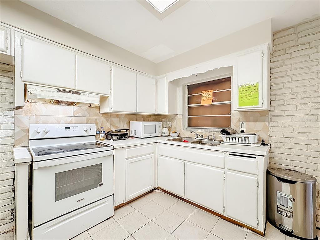4200 Anderson Road Orlando, FL 32812 - Photo 12 of 63 a kitchen with granite countertop white cabinets and white appliances