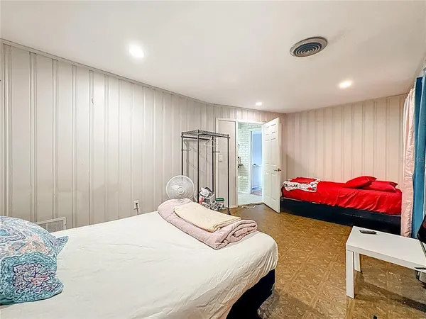 a bedroom with a bed and wooden floor
