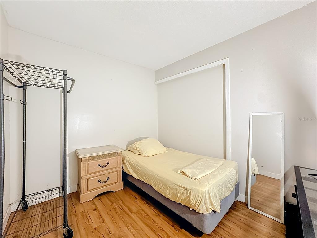 4200 Anderson Road Orlando, FL 32812 - Photo 33 of 63 a bedroom with a bed and wooden floor