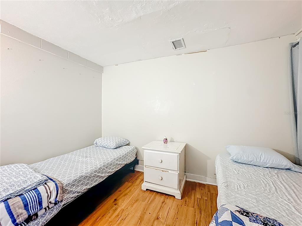 4200 Anderson Road Orlando, FL 32812 - Photo 38 of 63 a bedroom with a bed and wooden floor