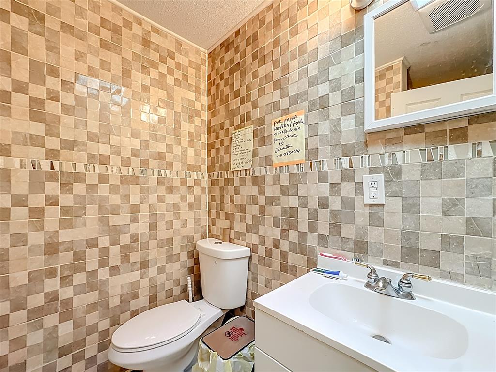 4200 Anderson Road Orlando, FL 32812 - Photo 47 of 63 a white toilet sitting next to a white sink and a shower curtain