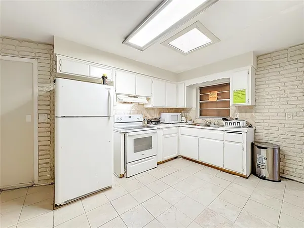 a view of a kitchen with furniture and refrigerator