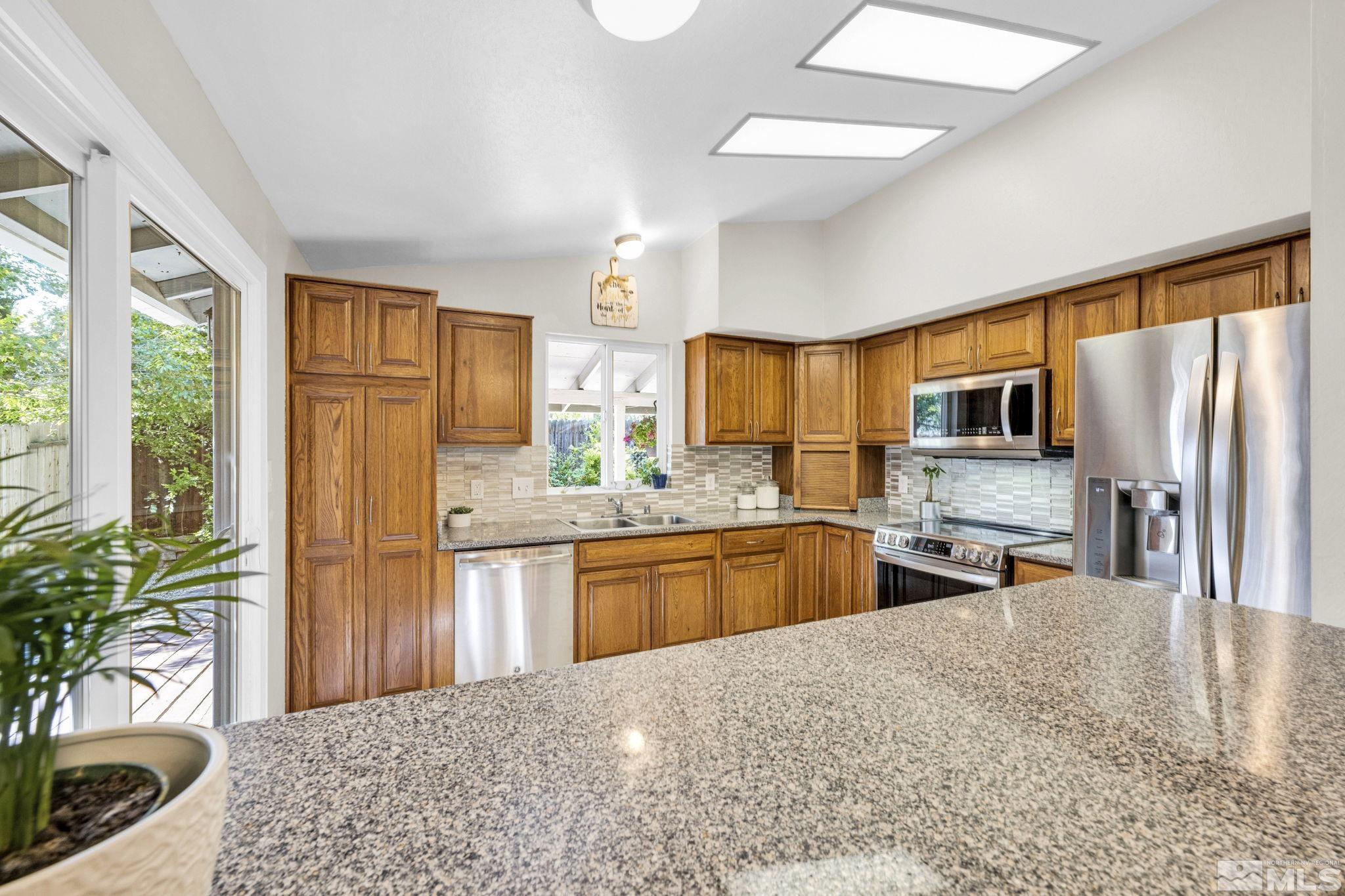 6314 Chesterfield Lane Reno, NV 89523 - Photo 15 of 35 a large kitchen with stainless steel appliances granite countertop lots of counter top space and wooden floor