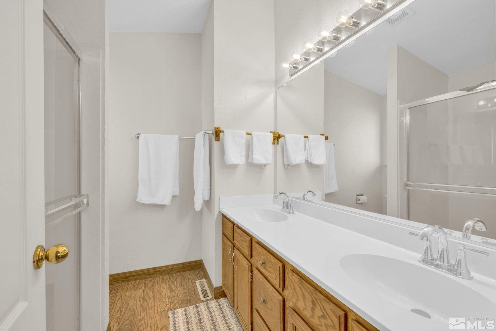 6314 Chesterfield Lane Reno, NV 89523 - Photo 19 of 35 a bathroom with a double vanity sink a mirror and a shower