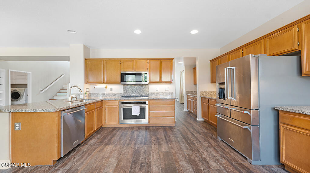 3443 Pine View Drive Simi Valley, CA 93065 - Photo 12 of 32 a kitchen with stainless steel appliances granite countertop a refrigerator a stove top oven a sink and dishwasher with wooden floor