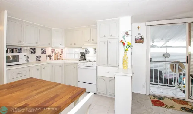 a kitchen with a refrigerator a stove a sink and white cabinets