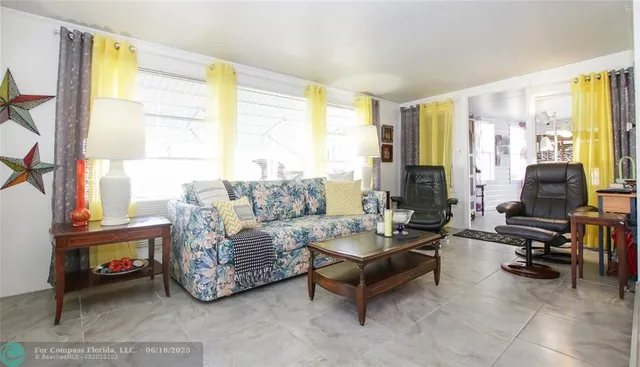 a living room with furniture and a floor to ceiling window