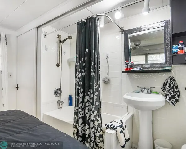 a bathroom with a sink mirror and shower