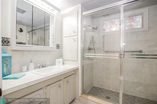 a bathroom with a shower sink and mirror