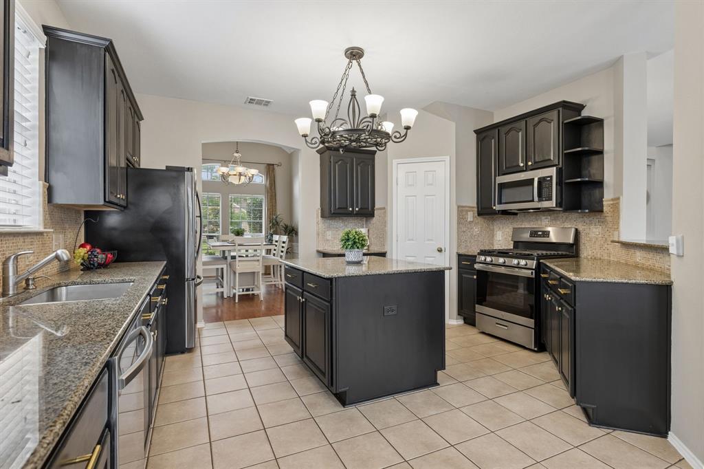 129 Timberbluff Lane Murphy, TX 75094 - Photo 9 of 34 a kitchen with stainless steel appliances granite countertop a stove oven and a refrigerator