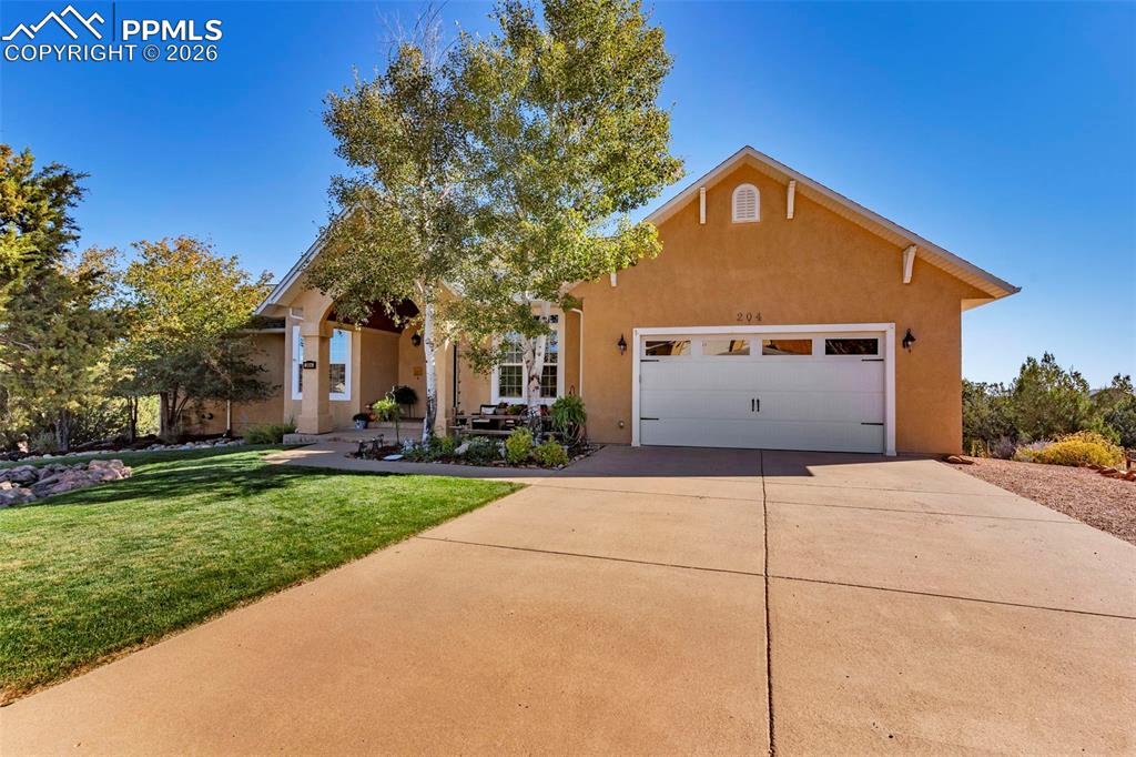 204 Storm Ridge Drive Canon City, CO 81212 - Photo 1 of 50 a front view of a house with a yard and garage