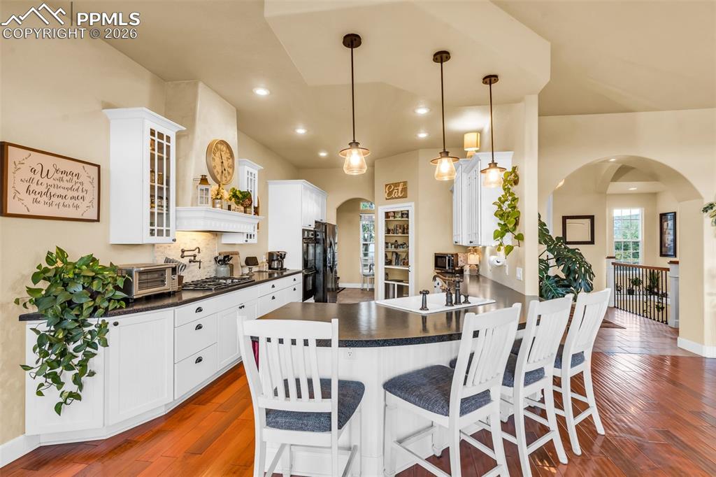 204 Storm Ridge Drive Canon City, CO 81212 - Photo 13 of 50 a kitchen with stainless steel appliances kitchen island granite countertop a table chairs and a refrigerator