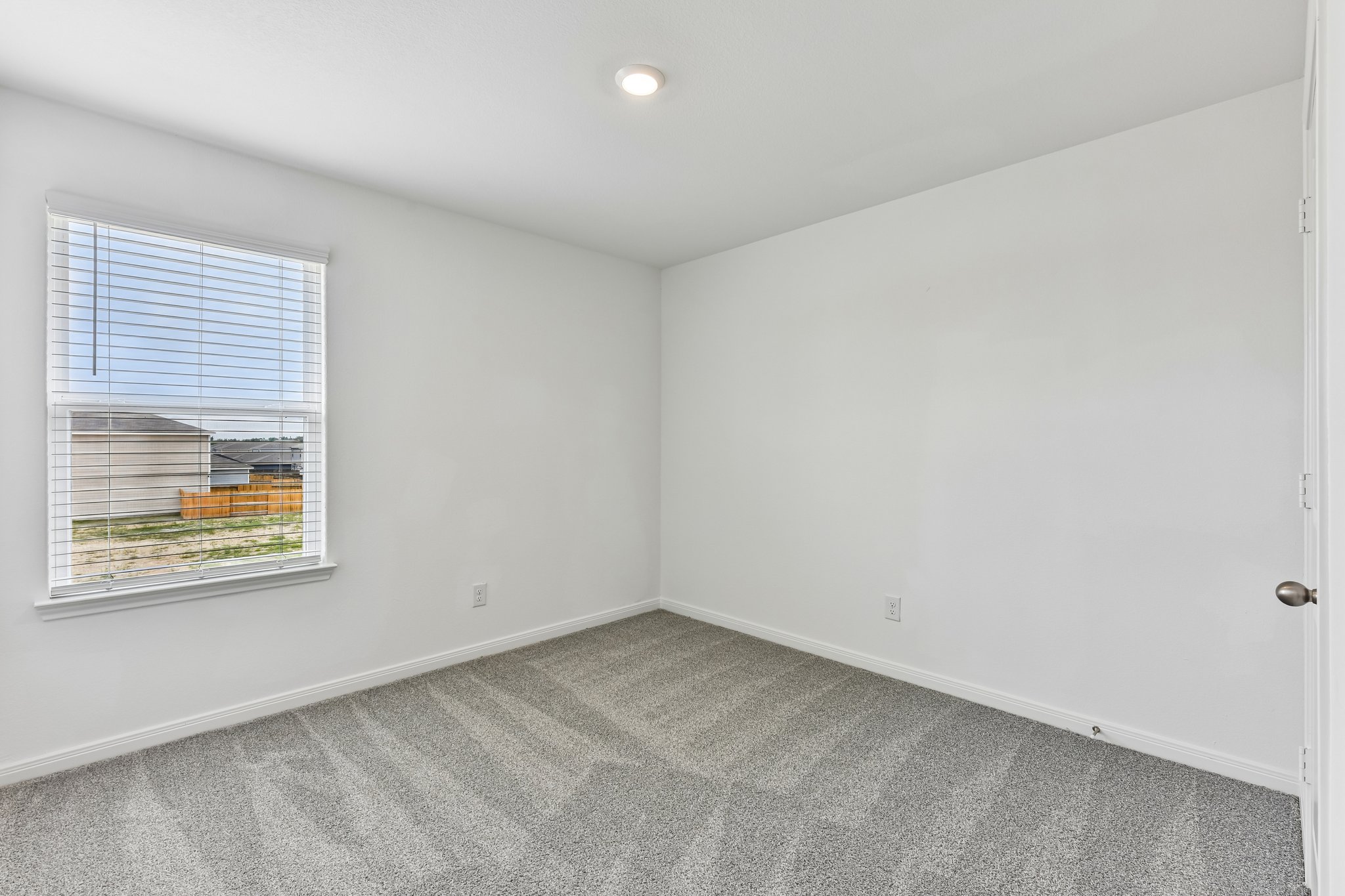 346 Low Pasture Trail Maxwell, TX 78656 - Photo 13 of 29 Neutral interior featuring light gray patterned carpeting, white painted walls, and a single recessed ceiling light fixture