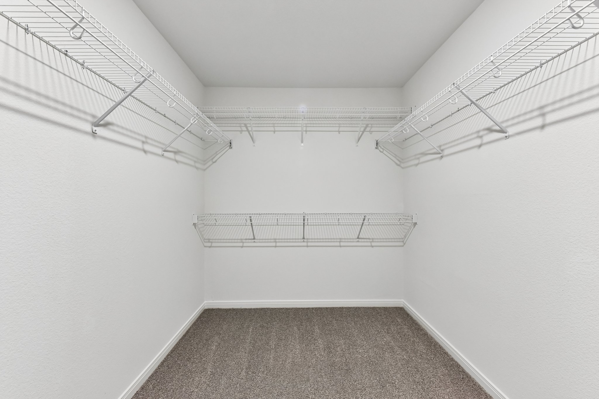 346 Low Pasture Trail Maxwell, TX 78656 - Photo 16 of 29 Walk-in closet featuring white wire shelving, white textured walls, and grey carpet flooring