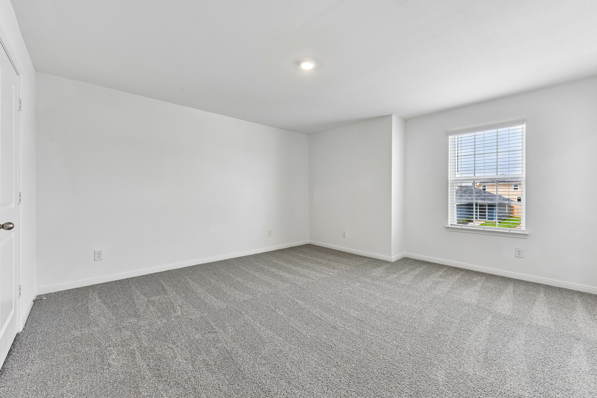 346 Low Pasture Trail Maxwell, TX 78656 - Photo 23 of 29 Spacious room featuring neutral paint, gray patterned carpeting, a single window with blinds, a white paneled door, and recessed lighting