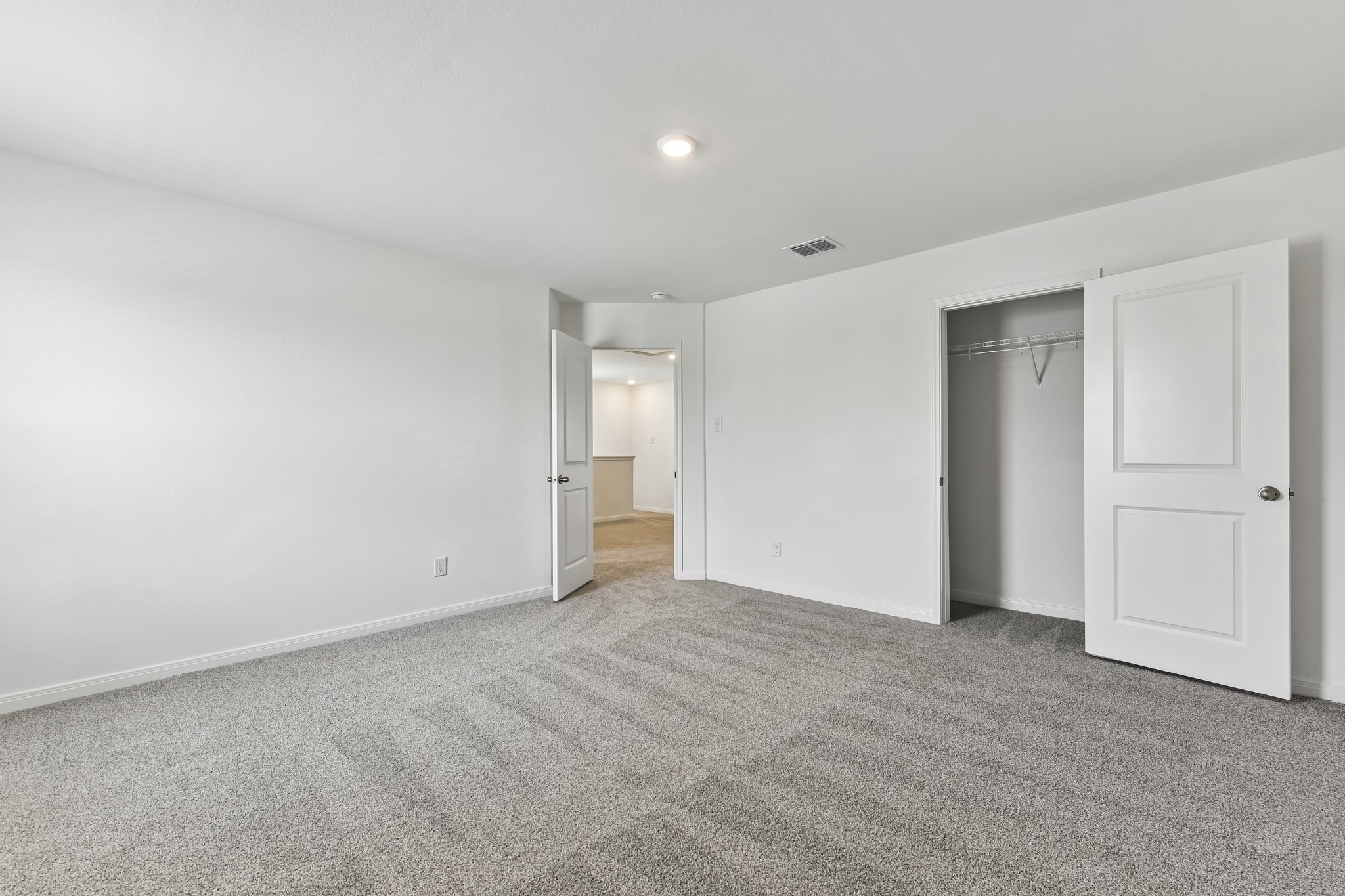 346 Low Pasture Trail Maxwell, TX 78656 - Photo 24 of 29 Neutral gray carpeted room with white walls, a single recessed ceiling light, and a built-in closet with a hanging rod