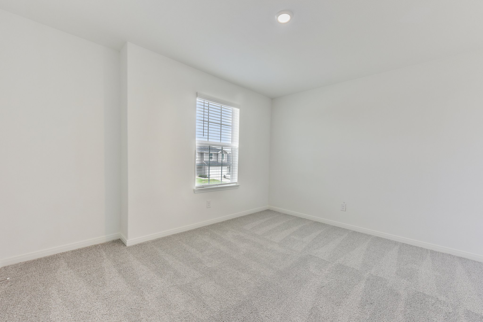 346 Low Pasture Trail Maxwell, TX 78656 - Photo 25 of 29 Bright interior space featuring a window with blinds, recessed lighting, neutral paint, and light-toned carpet flooring