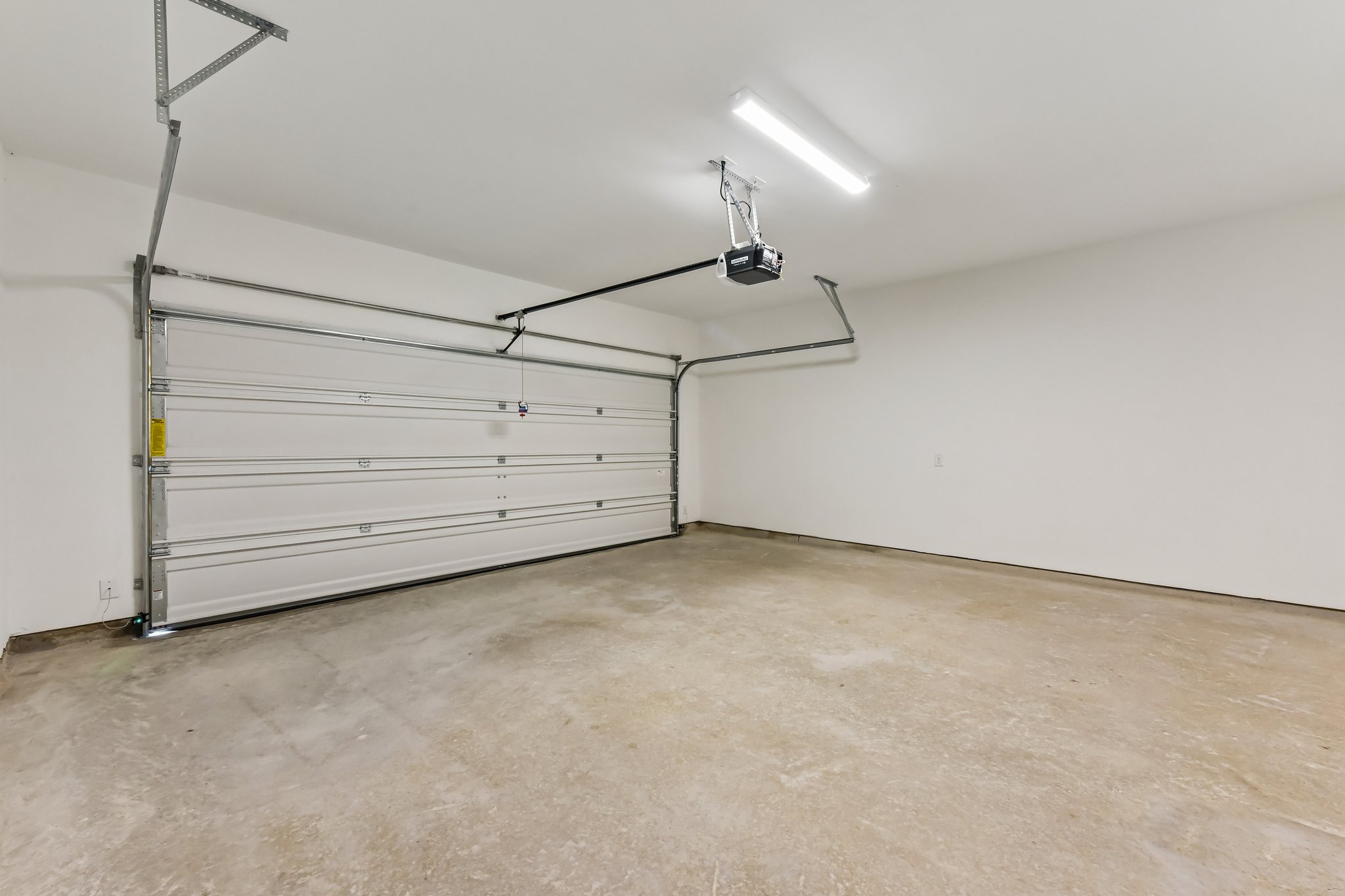 346 Low Pasture Trail Maxwell, TX 78656 - Photo 27 of 29 Spacious garage featuring a concrete floor, white walls, and a sectional garage door with an automatic opener