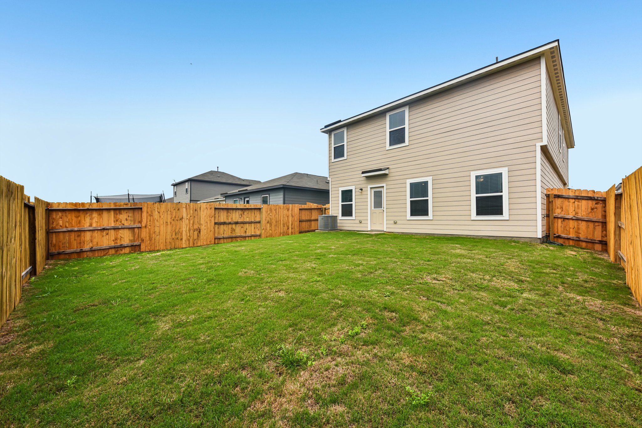 346 Low Pasture Trail Maxwell, TX 78656 - Photo 28 of 29 Expansive grassy backyard featuring a full wood privacy fence and a two-story exterior with neutral siding