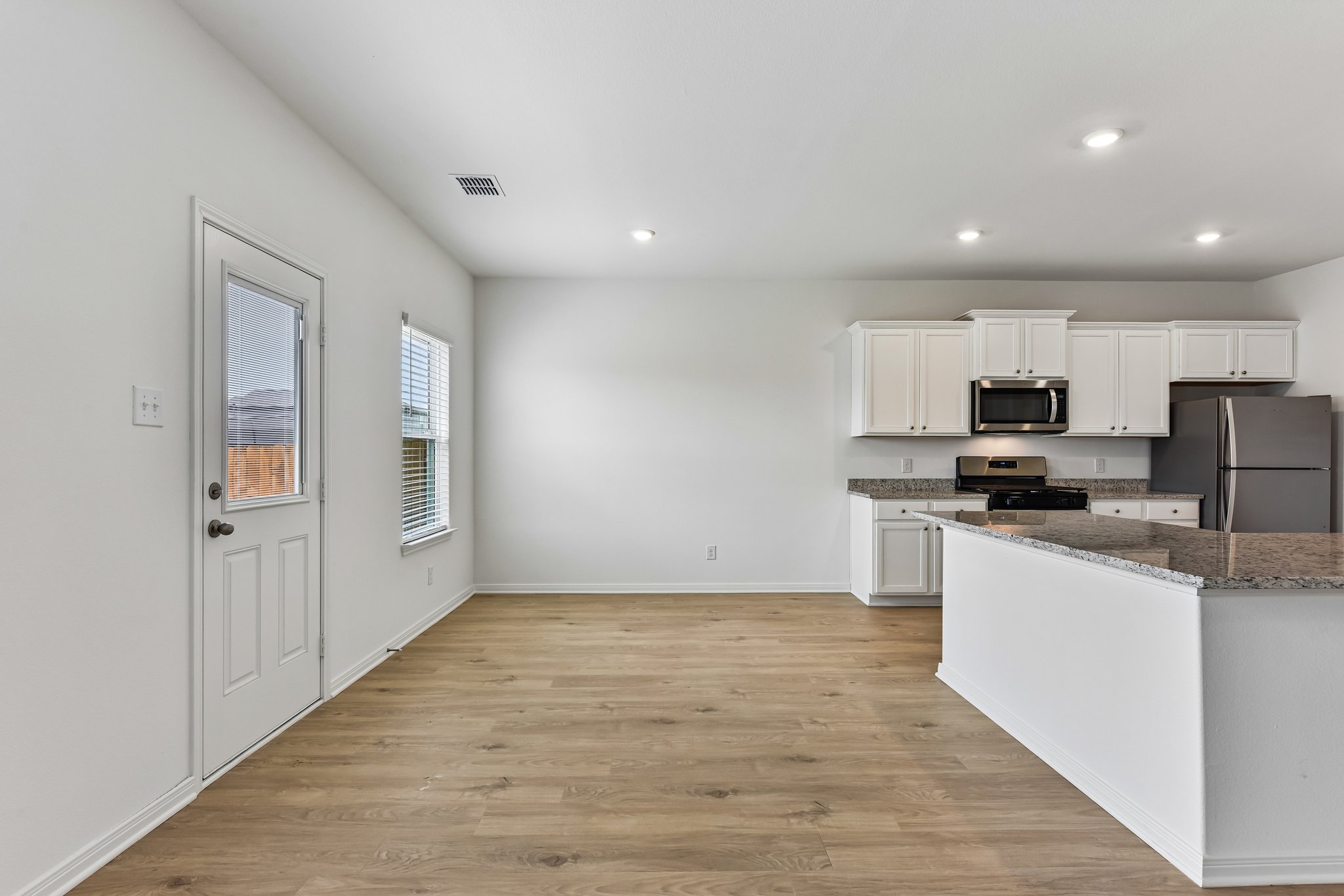 346 Low Pasture Trail Maxwell, TX 78656 - Photo 5 of 29 Kitchen featuring white cabinetry, granite countertops, stainless steel appliances, and recessed lighting