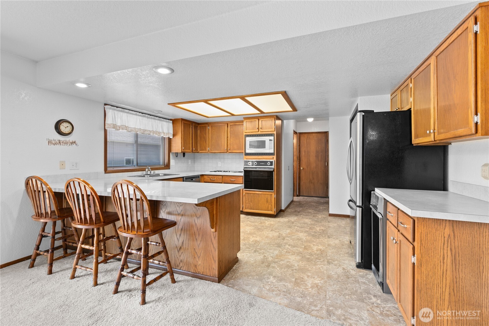 6929 Mission Road Everson, WA 98247 - Photo 10 of 36 a kitchen with stainless steel appliances kitchen island granite countertop a refrigerator and a stove top oven