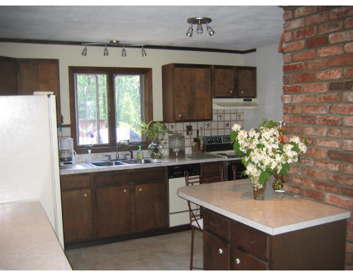 52 Gates Pond Road Berlin, MA 01503 - Photo 6 of 9 a kitchen with a sink refrigerator and cabinets